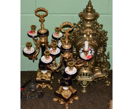 A large modern brass clock and a pair of gilt and porcelain candelabra