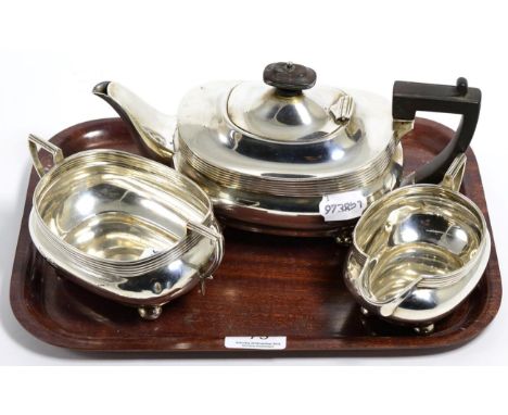 A silver three piece tea service, Joseph Rodgers, Sheffield 1915, rounded rectangular on bun feet, the teapot 26cm long 28ozt