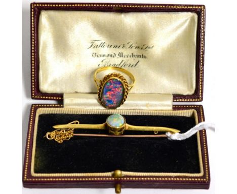 An opal bar brooch, stamped '15CT', 4.7g and a 9 carat gold opal doublet ring, finger size O1/2, 5.1g (2)