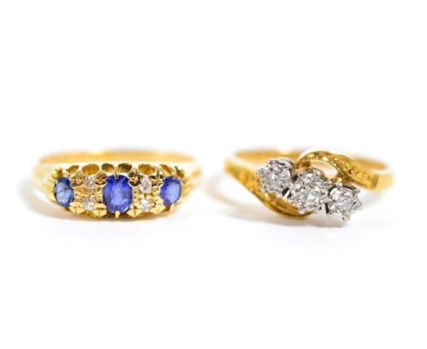 An 18 carat gold sapphire and diamond ring, finger size K1/2 and a diamond three stone ring, total estimated diamond weight 0