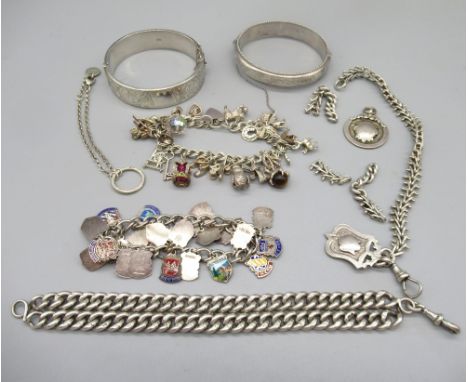 Two hallmarked sterling silver bangles, two silver fob charms, a silver enamel travel charm bracelet and other silver and whi