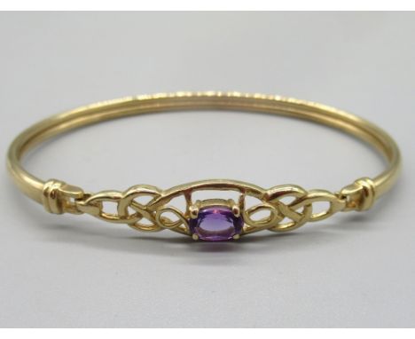 9ct yellow gold bangle with openwork front set with oval purple stone, the front opening with hook clasp, stamped 375, 5.66g 