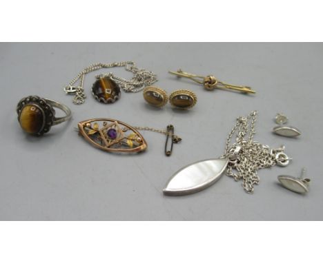 Yellow metal oval brooch set with amethyst, a yellow gold knot brooch, a pair of yellow metal earrings set with set with cabo