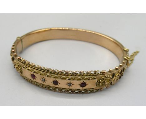 9ct yellow gold ornate hinged bangle set with three red stones and two diamonds in star cut settings, stamped 375, 11.45g 