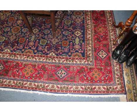 A TABRIZ RED AND BLUEGROUND CARPET with symmetrical floral patterns and multiple banded border, 380 x 310cm