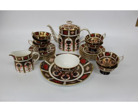 A ROYAL CROWN DERBY OLD IMARI PATTERN TEA SET consisting of a teapot, milk jug, sugar bowl, six saucers, seven cups, six tea 