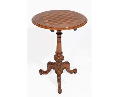 A VICTORIAN WALNUT CIRCULAR TILT TOP CHESS TABLE with decorative inlay and the carved column support on tripod base 52cm diam