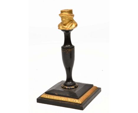 A 19TH CENTURY WOODEN CANDLESTICK the top modelled as a man's head, on ebonised turned support and square stepped base 22cm t