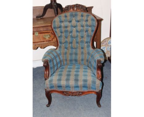 A VICTORIAN MAHOGANY BUTTON UPHOLSTERED ARMCHAIR with carved cresting rail, carved arms and conforming legs, approximately 68