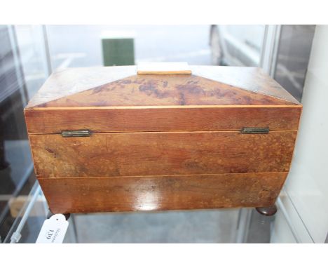 A REGENCY YEW WOOD TEA CADDY of sarcophagus form with fitted interior and lion mask ring handles and bun feet 32cm wide
