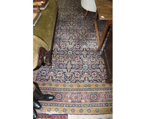 A PERSIAN BLUE GROUND CARPET with all over foliate decoration within a double border, retailed by Chamberlain King &Jones Ltd