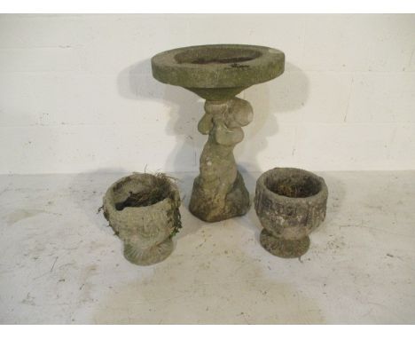A concrete garden birdbath with cherub base, height 60cm, along with two small concrete urns 