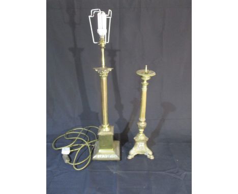 A freestanding brass lamp, along with a brass candle holder