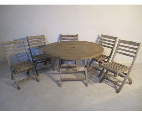 A round wooden garden table with five matching chairs