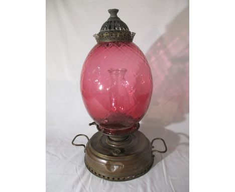 A brass Thermidor Belge oil lamp with cranberry glass shade - overall height approx.55cm.
