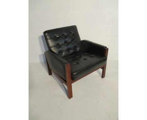 A retro black vinyl button-back arm chair