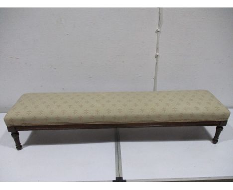 An Edwardian long foot stool on turned reeded legs