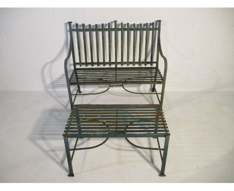 A wrought iron strapwork bench with matching table