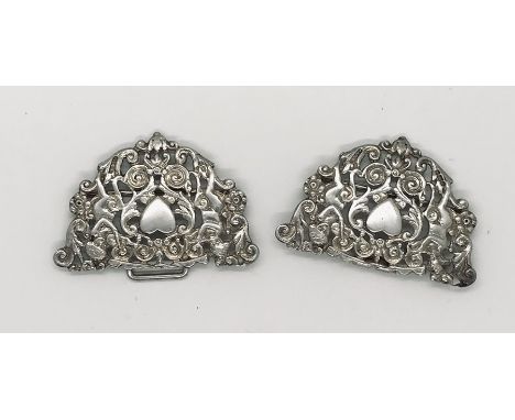 A hallmarked silver buckle decorated with love hearts and two cherubs playing a pipe and violin