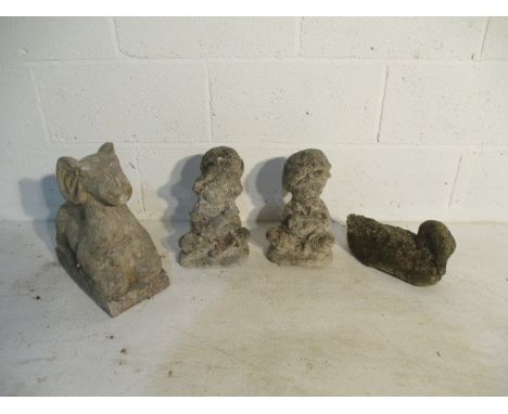 A collection of four small concrete garden ornaments including a young boy and girl holding pets, a duck and a ram.