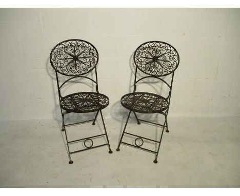 A pair of wrought iron folding garden chairs