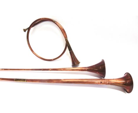 TWO COPPER COACHING HORNS lengths 82.5cm and 124cm and a French circular copper hunting horn, with suspension ring (3)