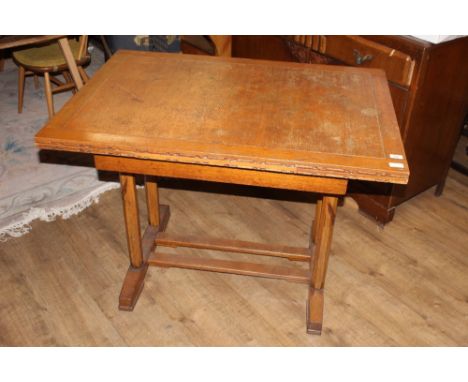 An early 20th century light oak drawer leaf dining table, with rectangular top with oblong draw out leaves over a trestle sty
