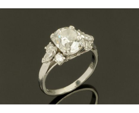 A Boodle &amp; Dunthorne platinum and diamond set ring, the cushion cut central stone approximately 1.2 carats with six small