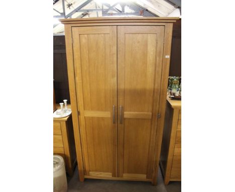 A modern light oak two door wardrobe, 195 cm x 108 cm x 60 cm.  CONDITION REPORT: Generally good used condition, some accumul