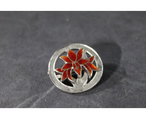An early Elizabeth II silver and red enamel circular brooch, decorated with a flower, 2.75 cm diameter. Hallmarked for Birmin