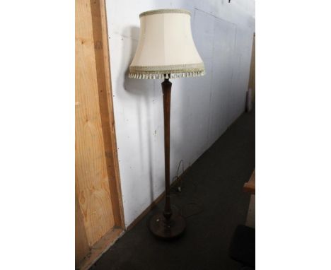 A early to mid 20th century turned and fluted mahogany standard lamp with green tasselled material shade. 152 cm to fitting. 