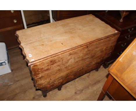 A 1920's oak gate leg table with shaped top edge and spiral turned legs, 105 cm x 150 cm x 73 cm high and a set of four ladde