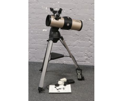 A Tasco Starguide telescope with computerised control on tripod with instruction manual and accessories.