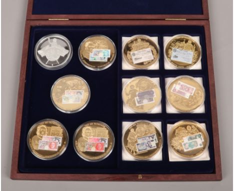 A quantity of gilt metal and enamel bank note coins.