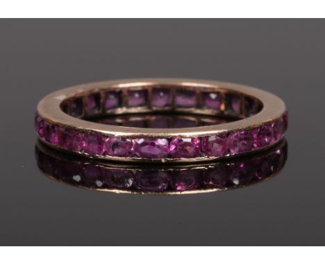 A gold and ruby eternity ring set with alternating round and ovoid cut stones. Unmarked, tested as 9ct, size N.