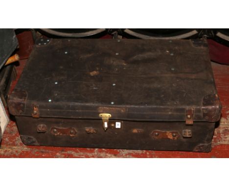 A leather travel trunk with reinforced corners and brass mounts bearing J.B monogrammed initials.