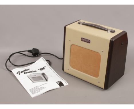 A Fender Champion 600 practice amplifier with instruction manual.