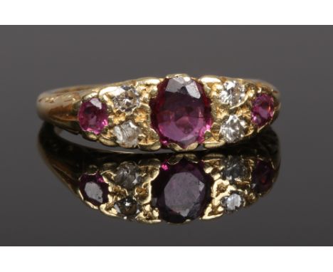 An 18ct gold ruby and diamond ring on scrolling shank. Size N.