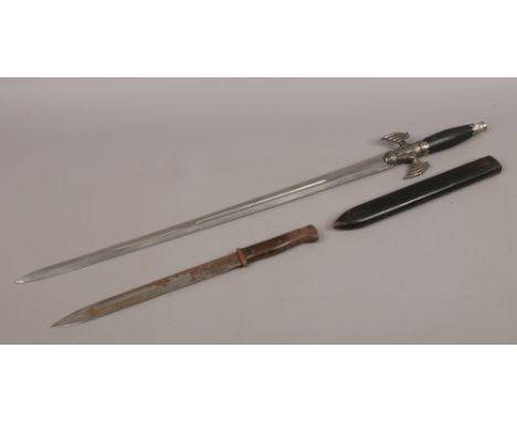 A decorative fantasy themed sword along with bayonet in wooden scabbard.