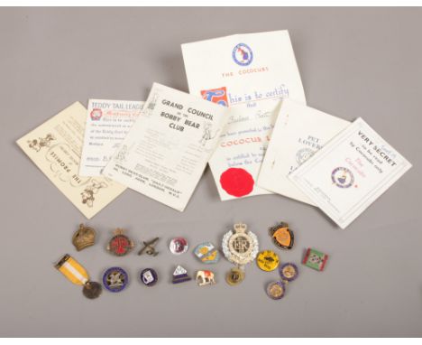 A quantity of mostly vintage enamel pin badges including a Butlins example, along with several children's club booklets.