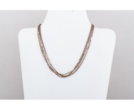 A yellow metal guard/muff chain of plain circular 2.8mm links interspersed by groups of a fluted sphere flanked by bar links.