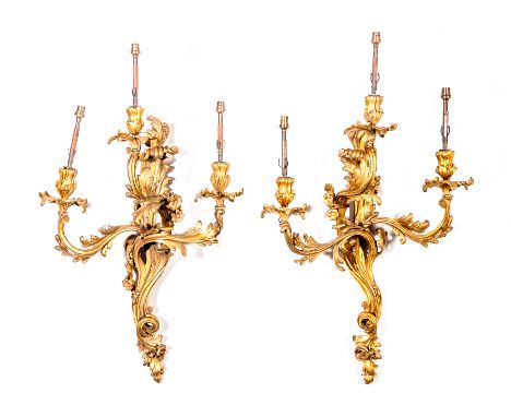 A pair of French gilt metal three-light wall brackets, second half of the 19th Century, rococo scrolls with acanthus and flow