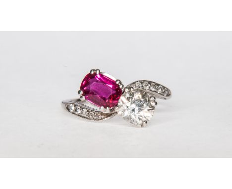A ruby and diamond traditional crossover ring, the old cut diamond and oval ruby claw set in a white metal mount with five sm