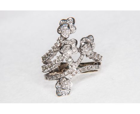 A diamond set dress ring, of cross-over design terminating in hearts and trefoils in an all white metal mount stamped 750.  T