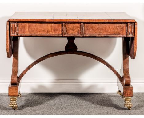 A Regency oak sofa table, broad crossbanding, two frieze drawers incorporating a central tablet, bead moulded outlines, shape