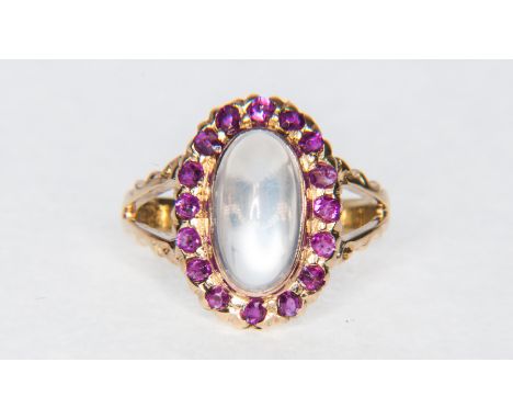A moonstone and ruby oval cluster ring, the oval cabochon cut moonstone 10.5mm x 6mm collet set and surrounded by rubies (16)