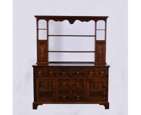 An oak dresser, 18th Century elements, two shelf rack under a moulded cornice piece, with a dentil corbel, with end cupboards