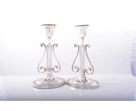 A pair of Edwardian silver table candlesticks, by Harrison Bros & Howson, London1904, lyre designed stems, oval bases with re