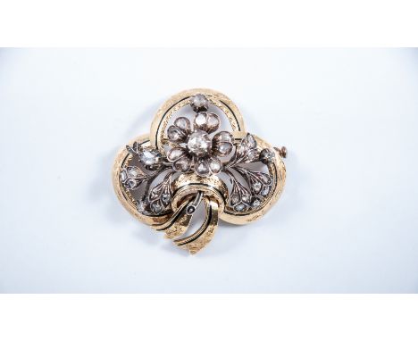 A Victorian yellow and white metal trefoil diamond set brooch, highlighted with black enamel and having a floral spray to cen