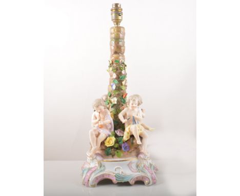 A pair of German porcelain bases, floral encrusted rustic columns, each modelled with four musical cherubs and scrolls, 39cm,